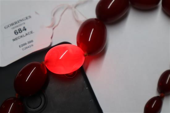 A single strand graduated simulated cherry amber necklace, gross weight, 114 grams, 82cm.